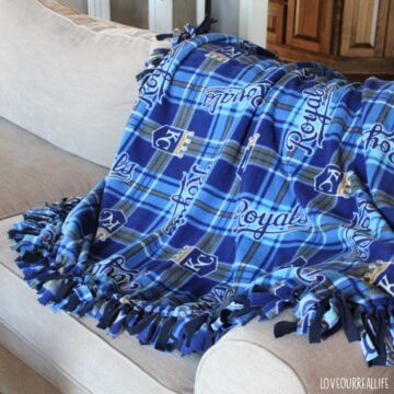 Blue Kansas City Royals fleece blanket on back of Pottery Barn couch.