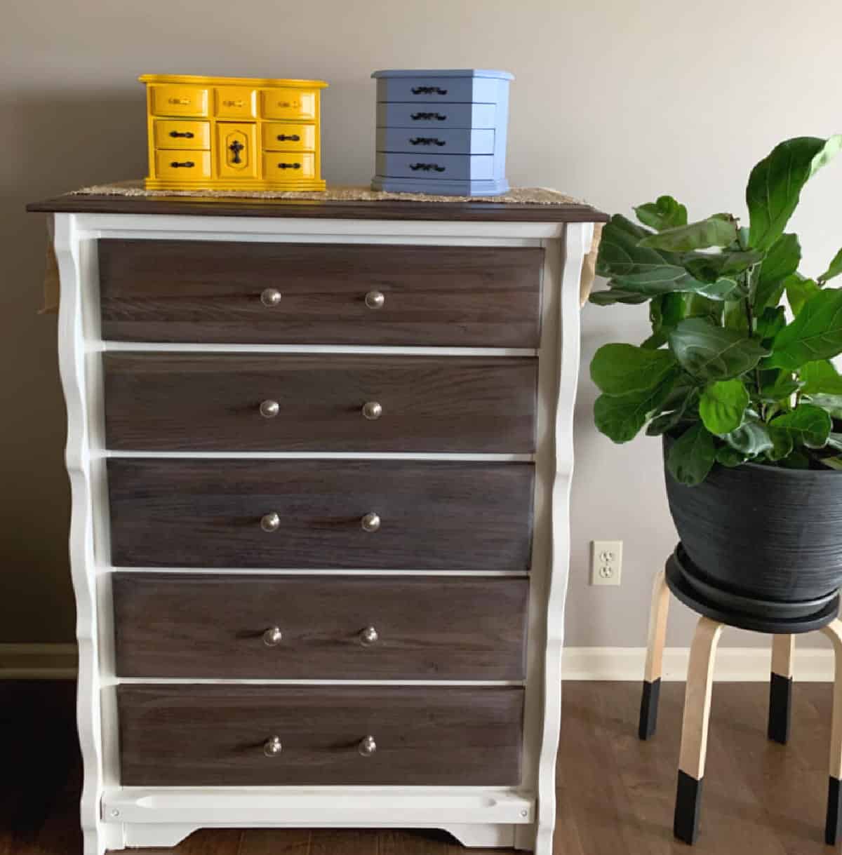 Chest of drawers with yellow and light blue jewelry box on top.