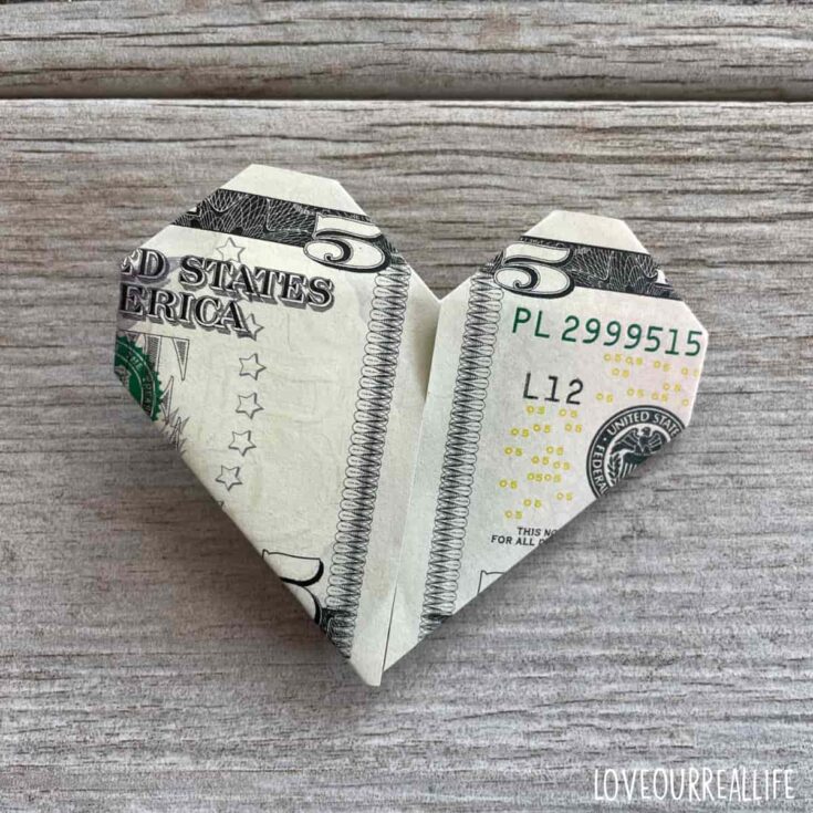 Money origami using five dollar bill to make a heart.