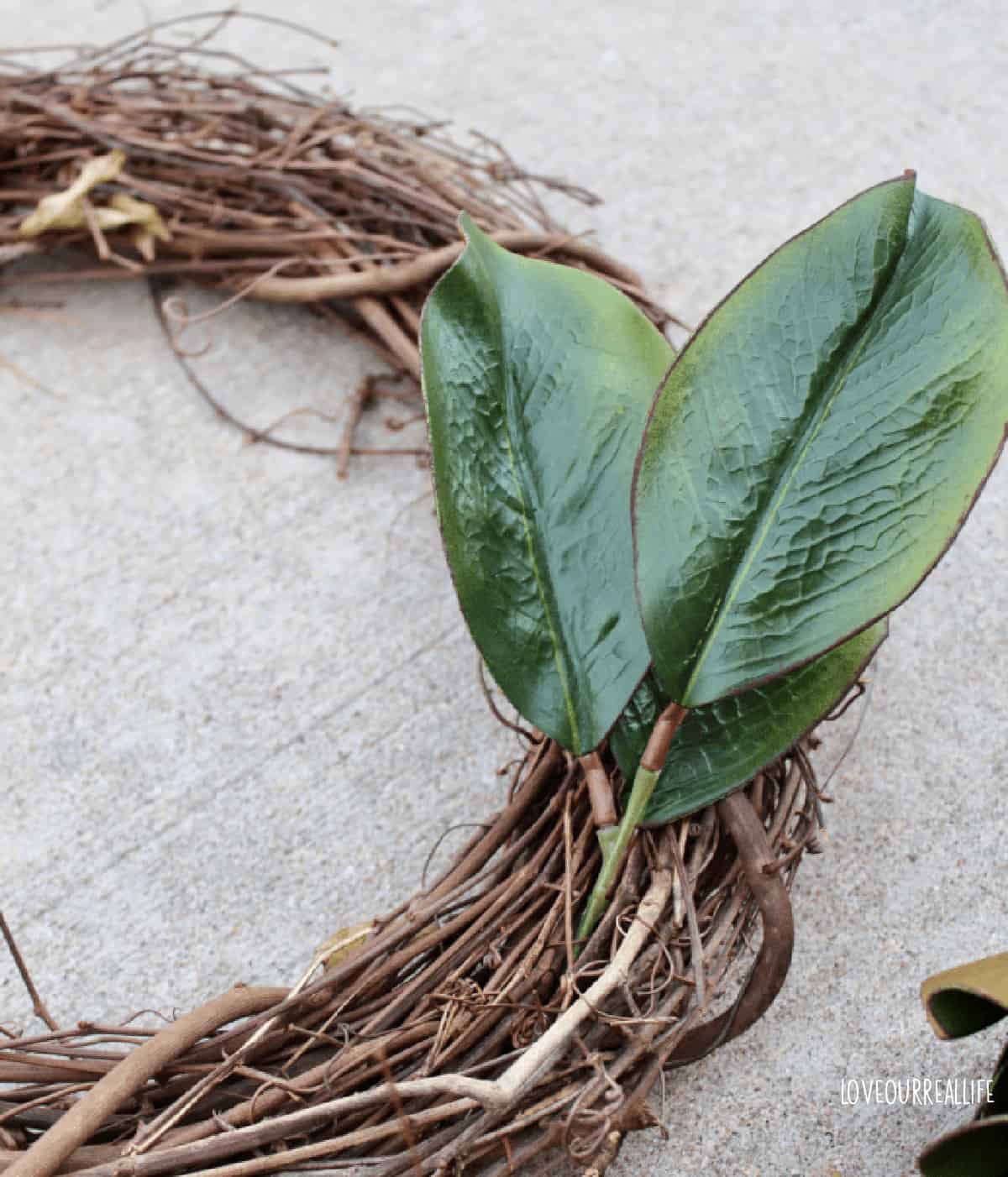 Pushing floral stems into wreath.