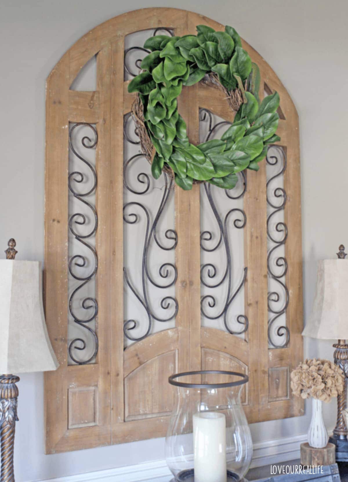 Wreath attached to wood wall hanging.