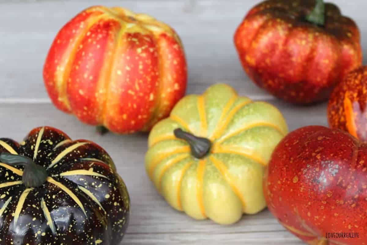 Several plastic pumpkins in orange, yellow and dark green.