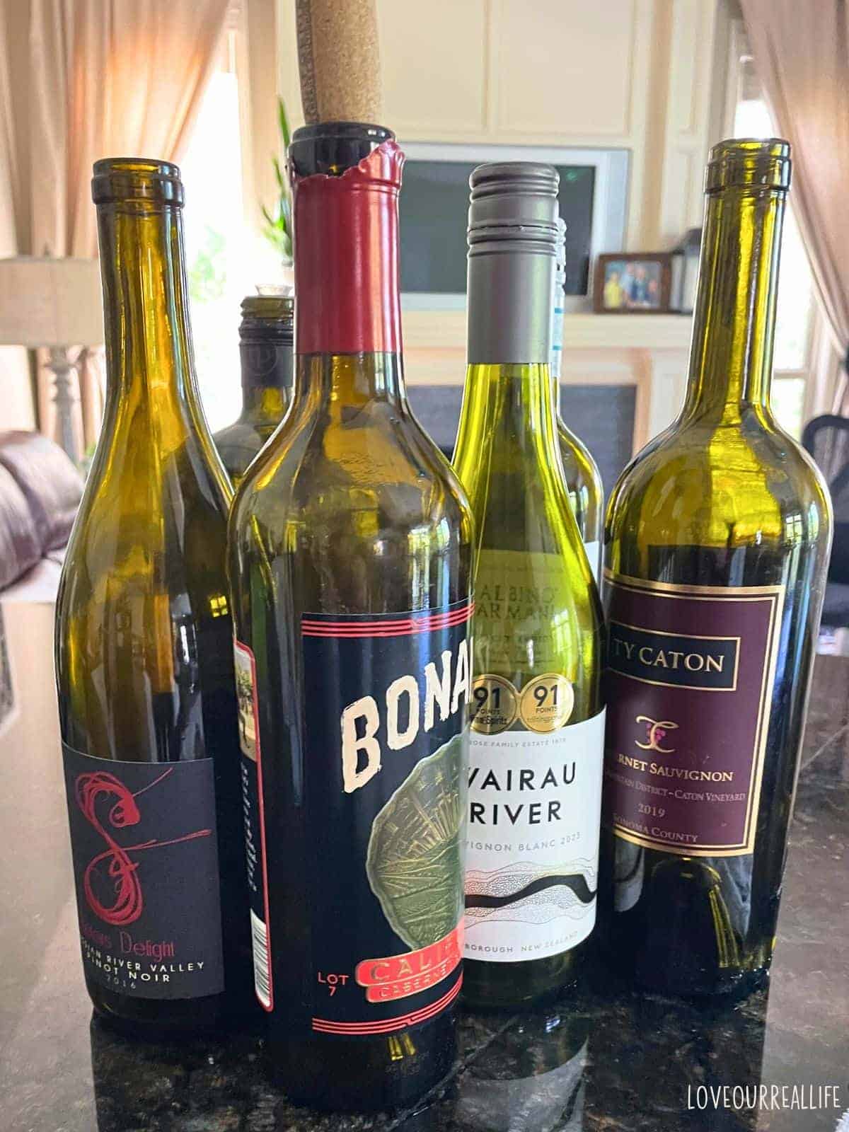 Various old wine bottles sitting on counter.