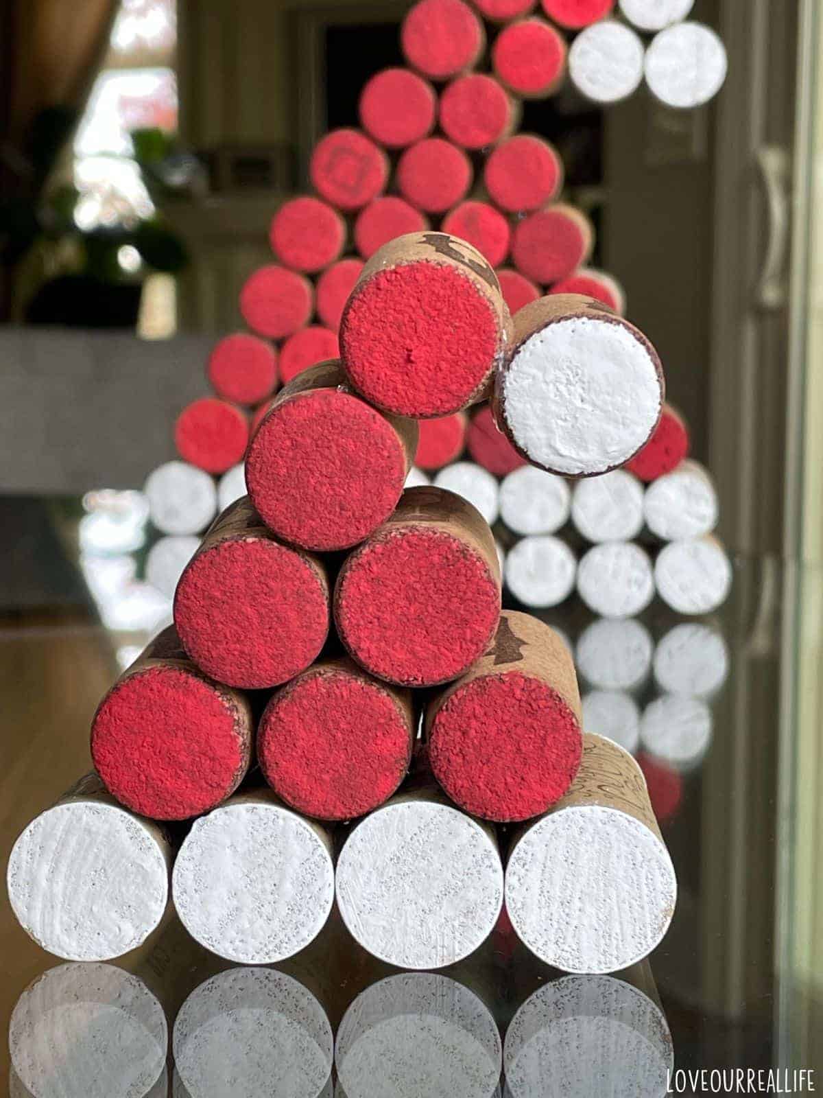 Close up of wine cork santa hat with larger hat in background.