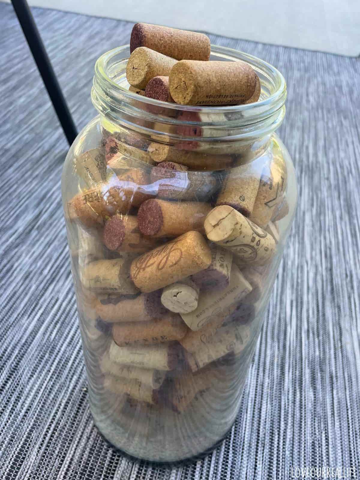 Many wine corks in clear, glass jar.