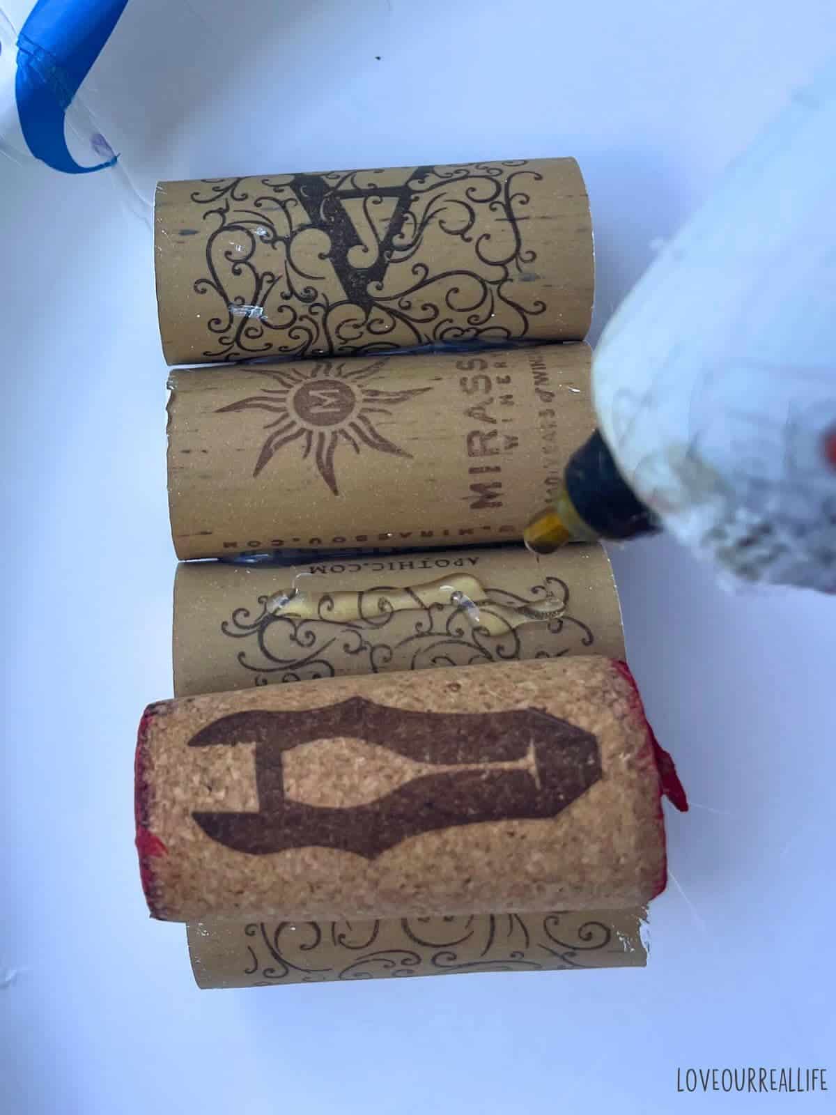 Hot glueing wine corks.