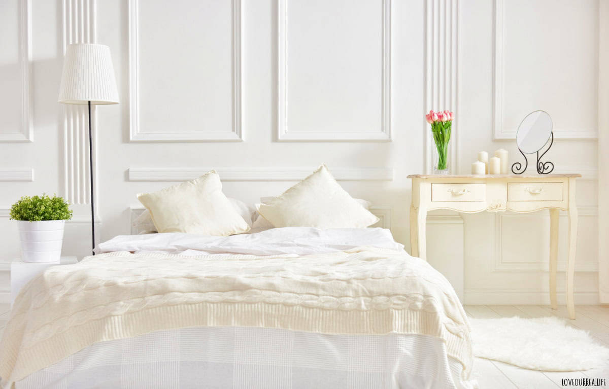 Bedroom decorated in mostly whites.